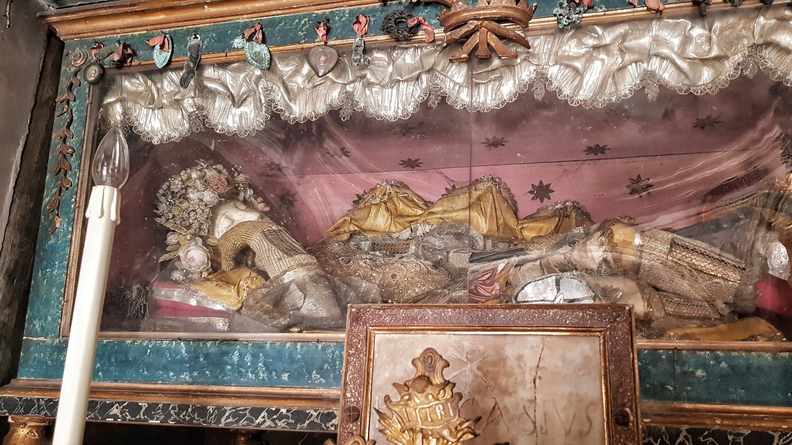 L'urna con le spoglie di San Pascasio sull'altare della cappella, con ex voto e lastra di marmo incisa